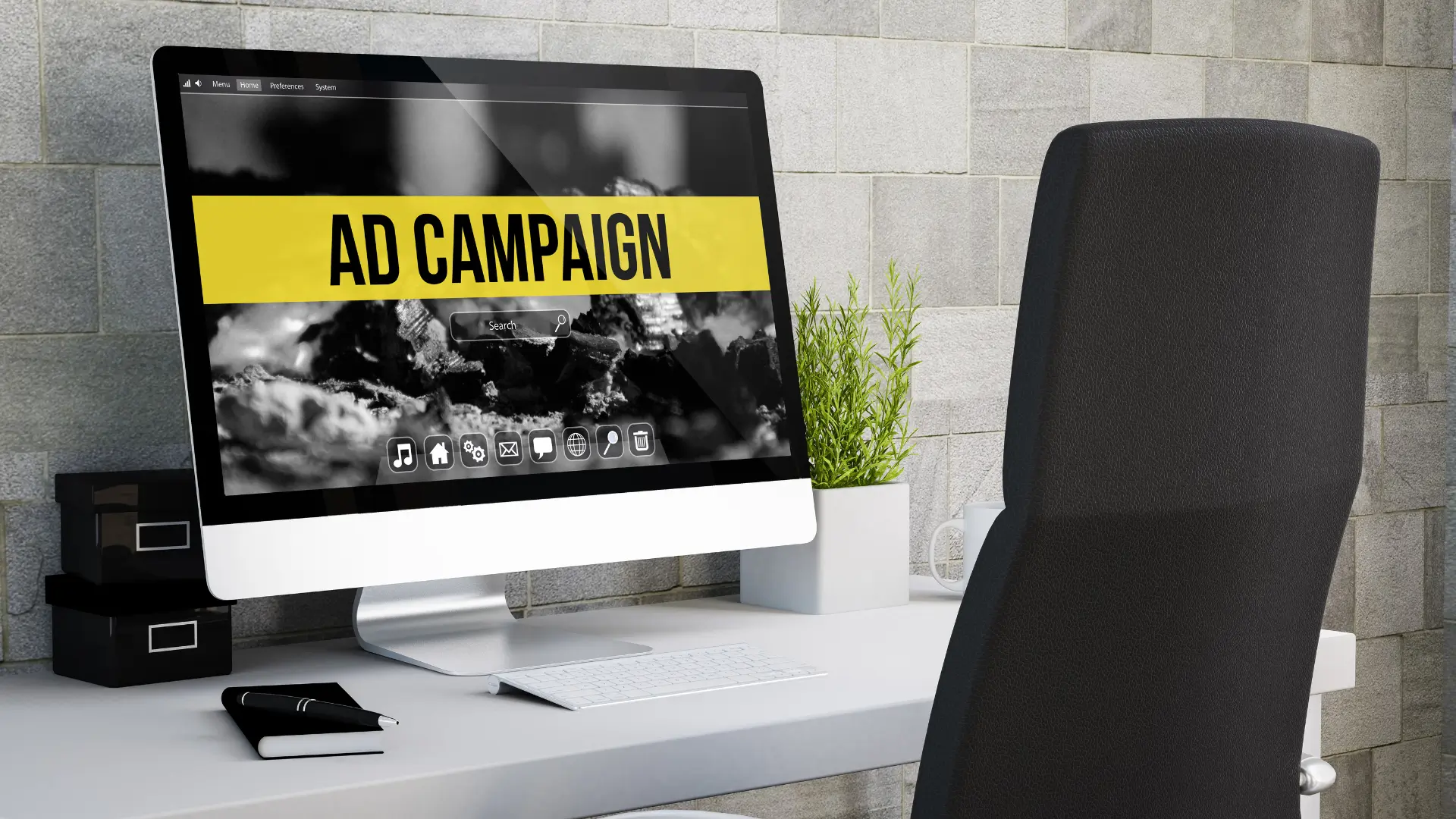 A Mac computer on a white desk with the words 'AD CAMPAIGN' on a yellow sign on the computer