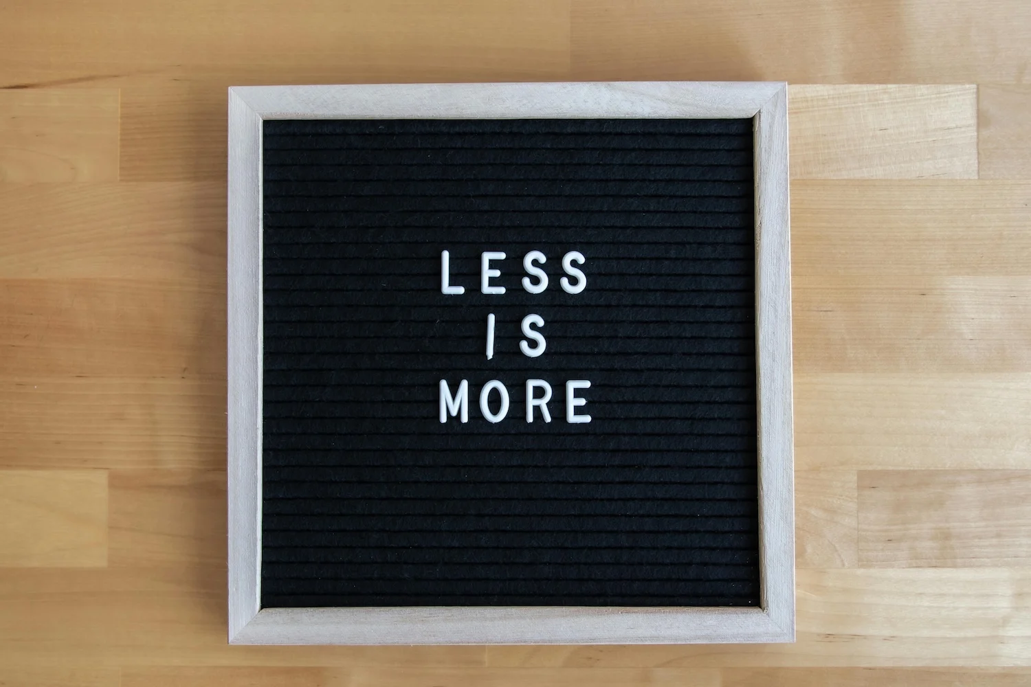 Board with 'Less is More' on it