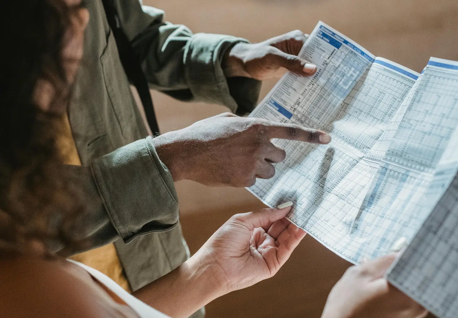 Man pointing at an instructions sheet that he holds with a woman