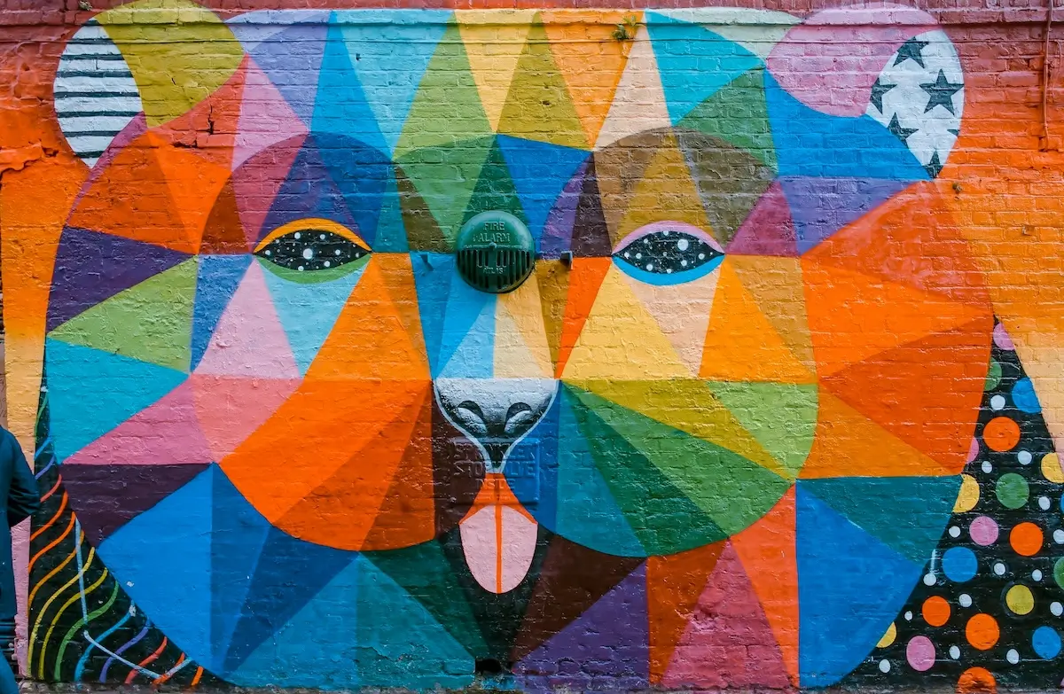 A colourful bear collage on a wall, made up of lots of different coloured triangles