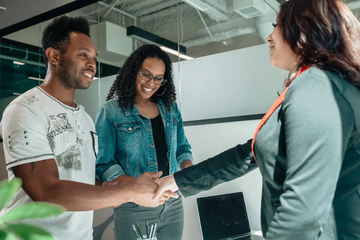 A black man shaking hands with a female expert