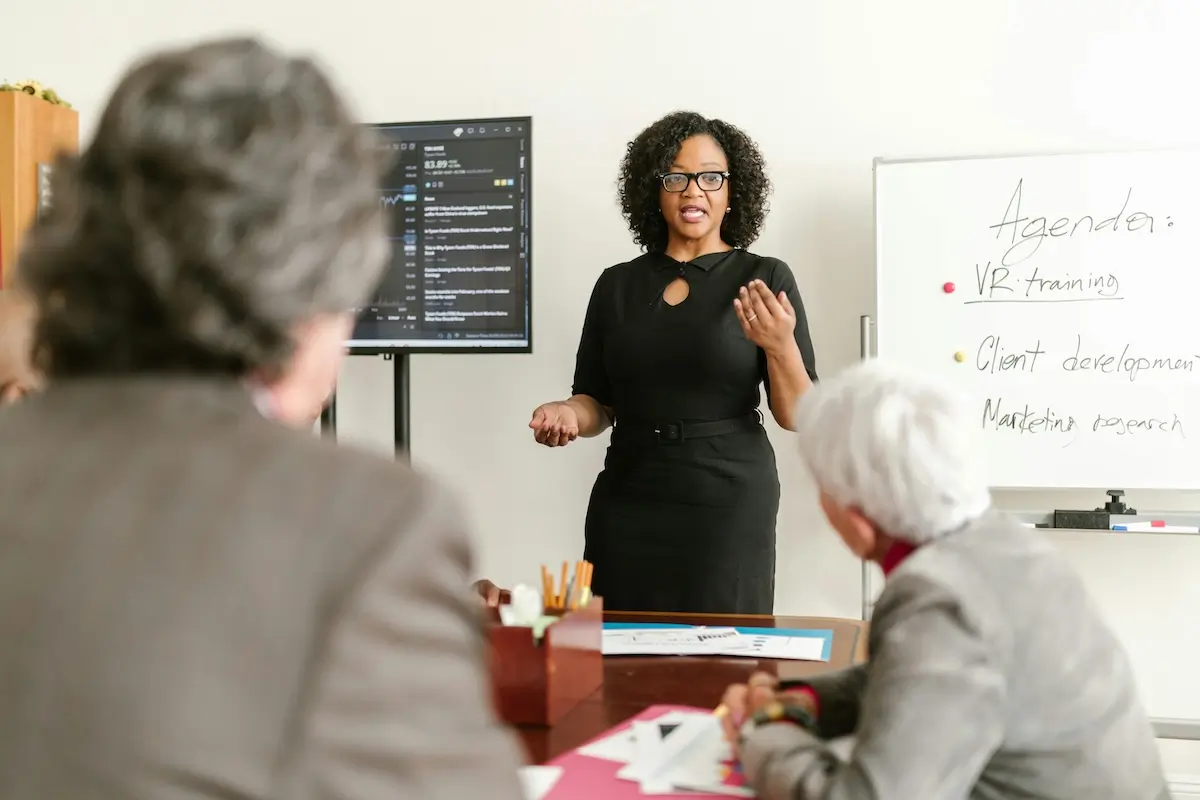 A woman standing in front of two mature women giving a speech