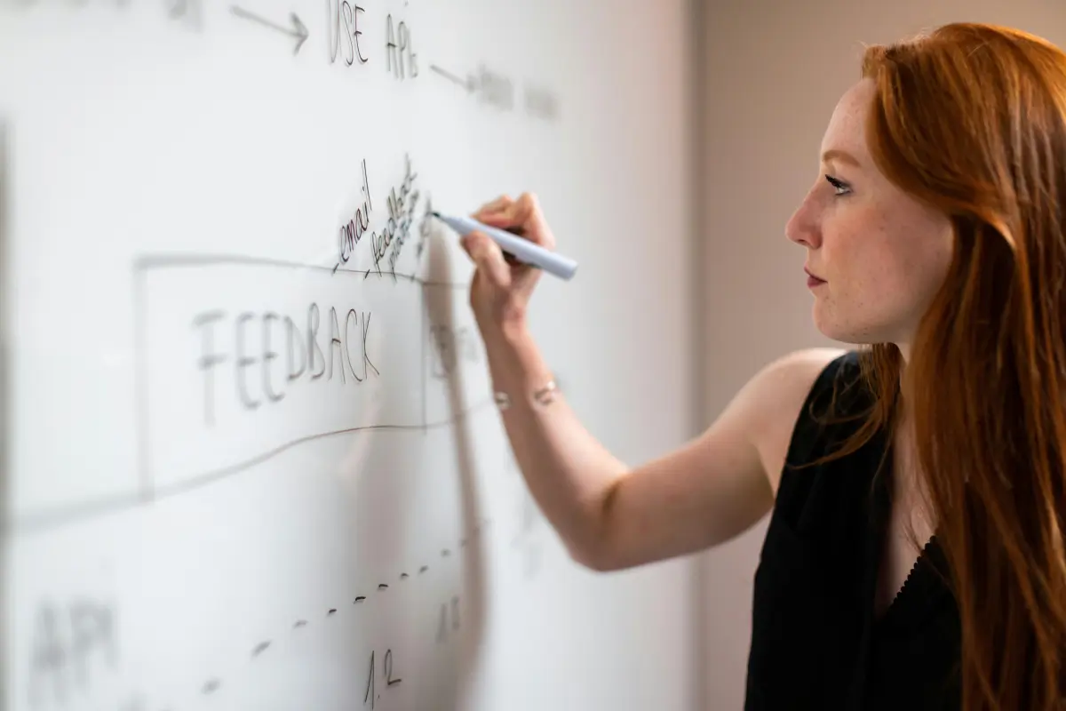 A woman writing on a white board