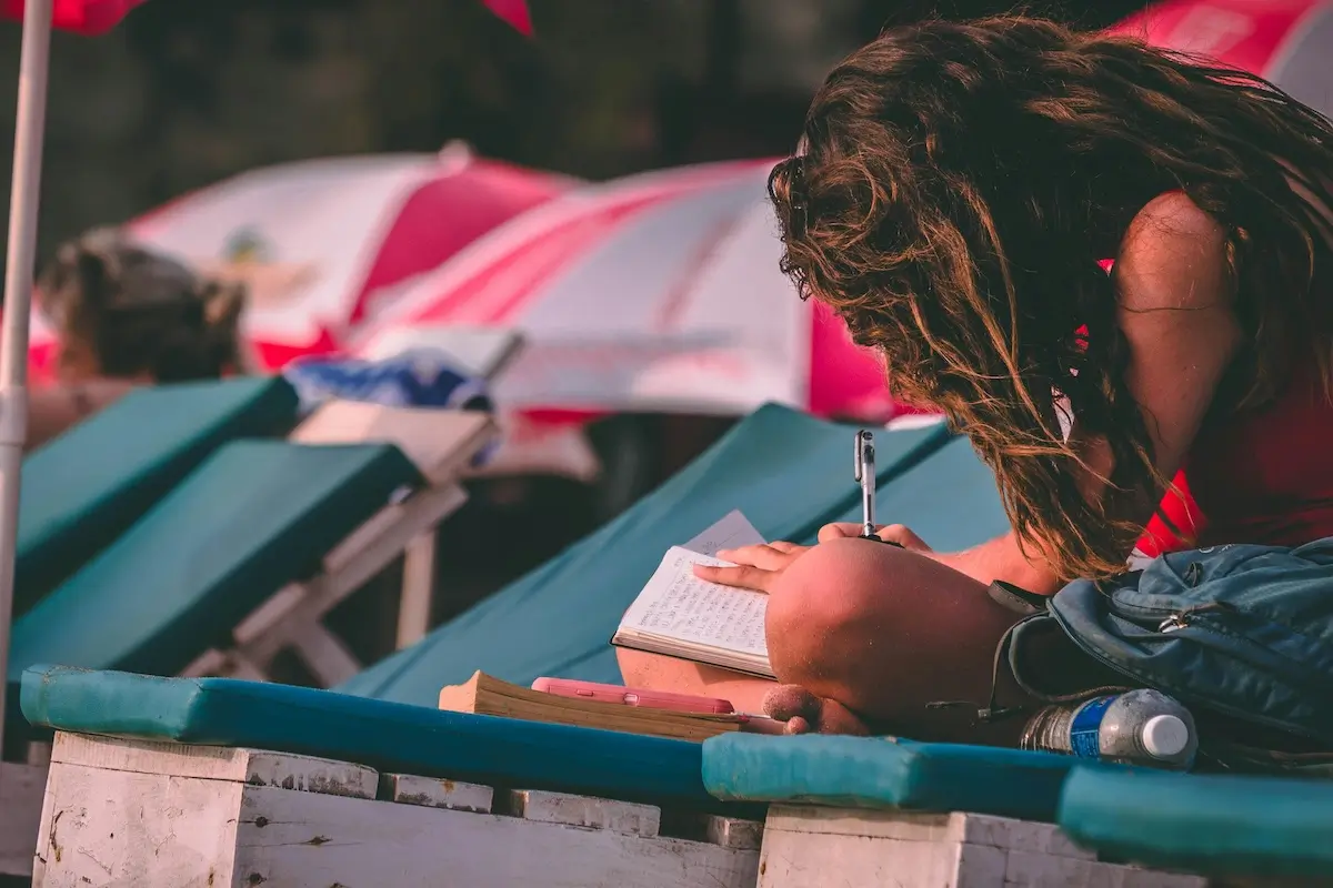 A woman writing on a sunlounger