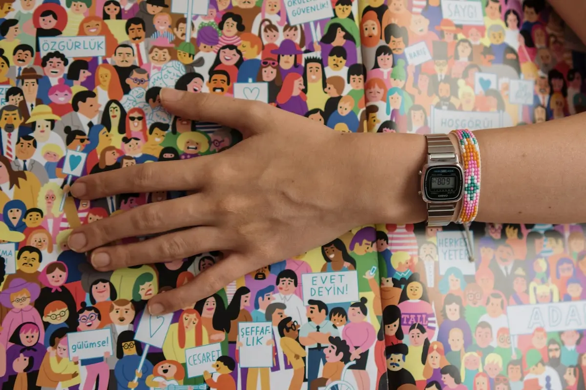 Hand across a picture of an animated crowd of the community
