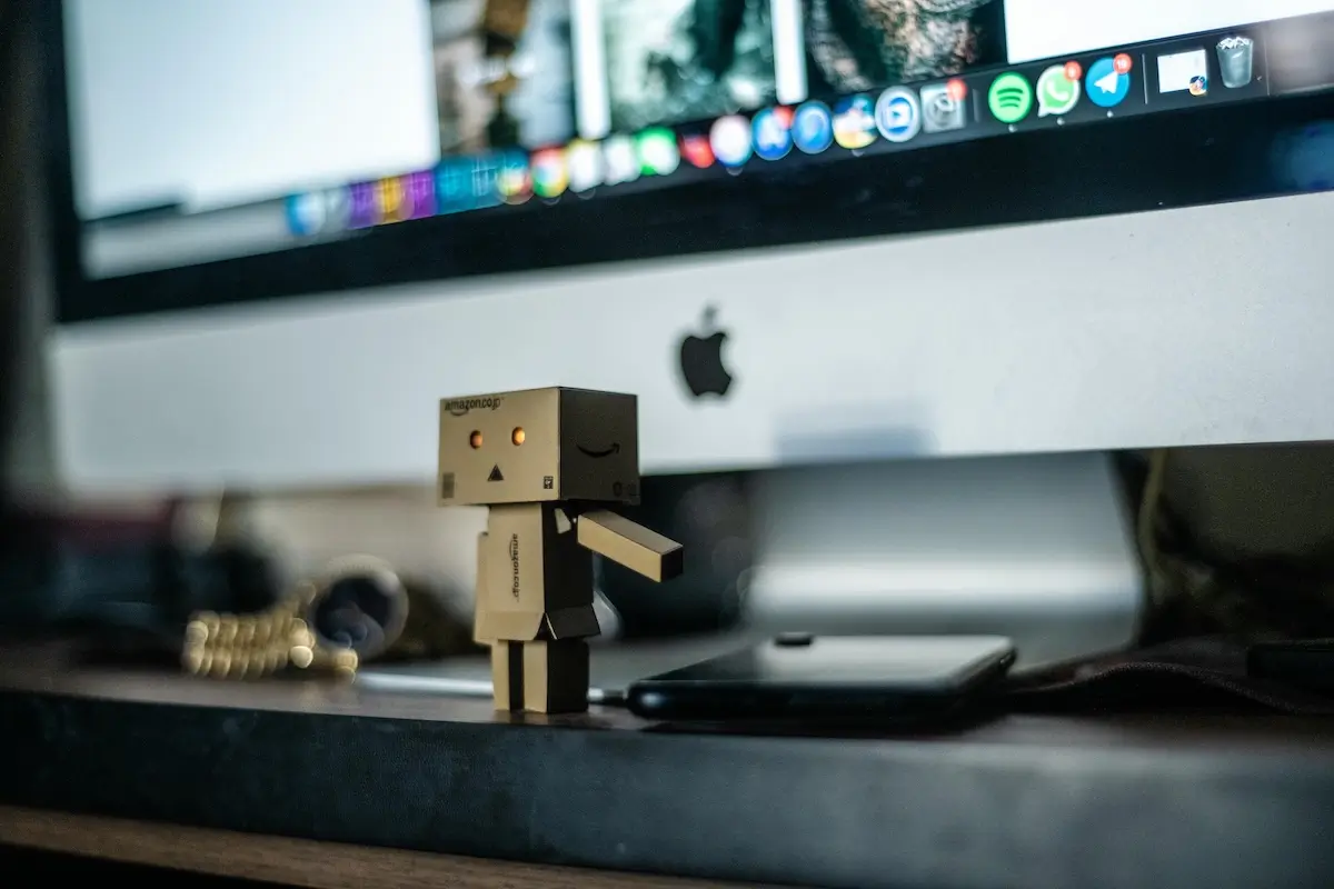 Robot toy in front of an Apple Computer
