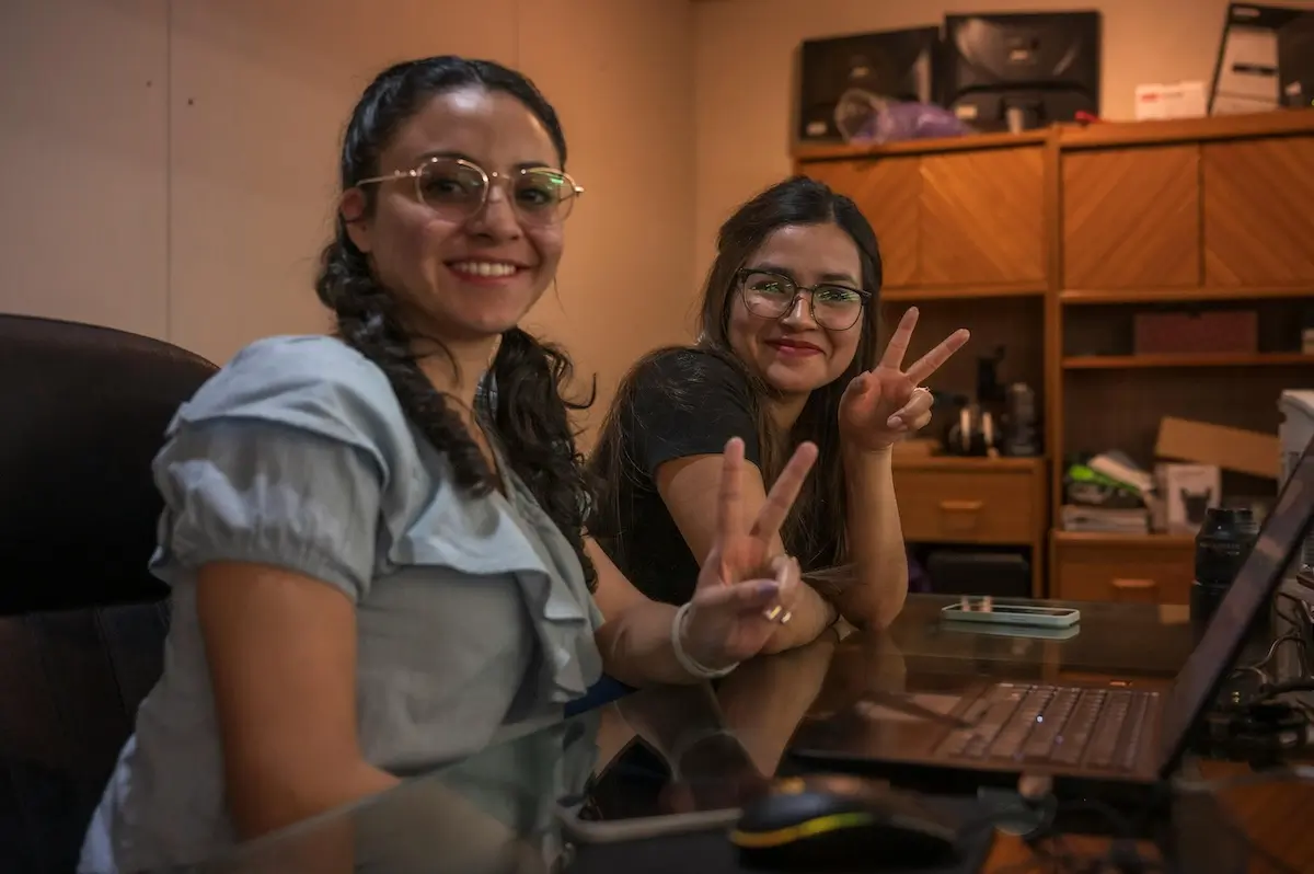 Two young Web3 women making the peace sign by their laptop by Israel Torres on Pexels. com