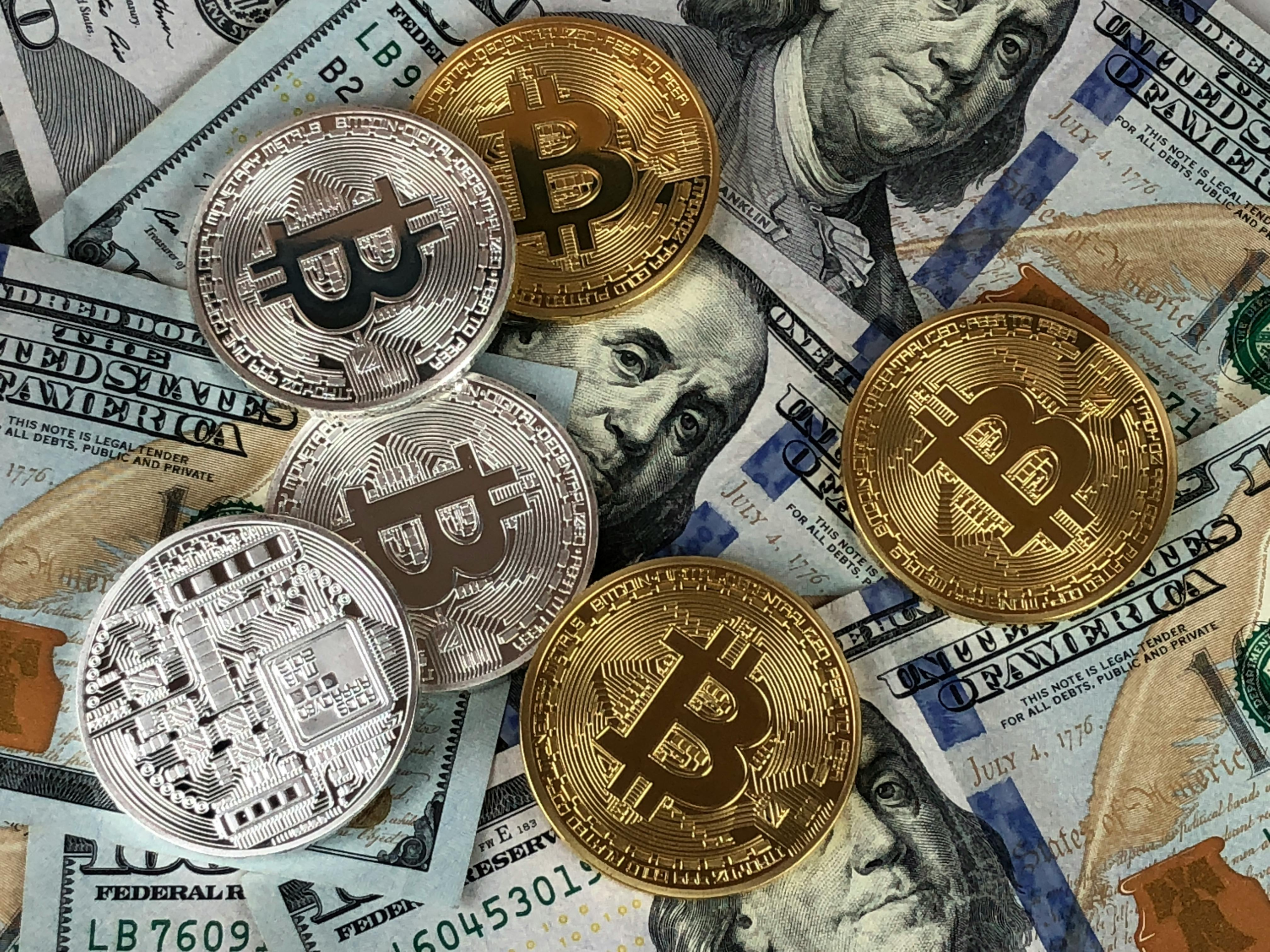 Bitcoins on top of US dollar notes by David McBee on Pexels. com