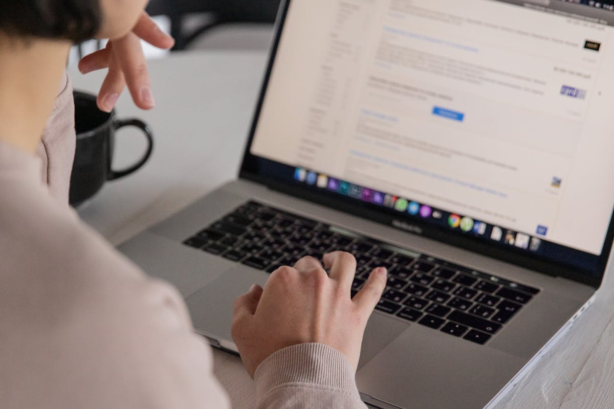 Crop unrecognizable businesswoman typing on laptop at home by KATRIN BOLOVTSOVA on pexel.com