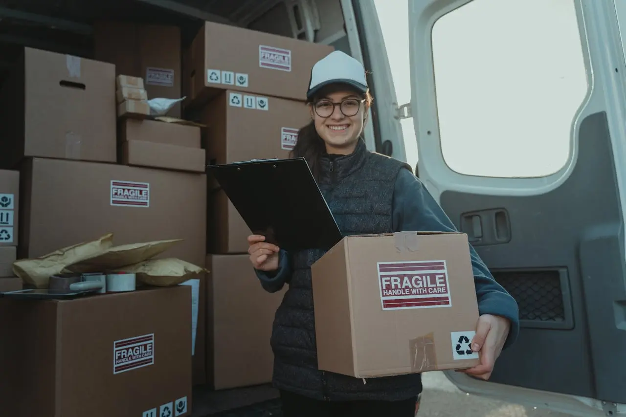 Female Courier carrying a Box and holding a Clipboard by Tima Miroshnichenko on Pexels. com