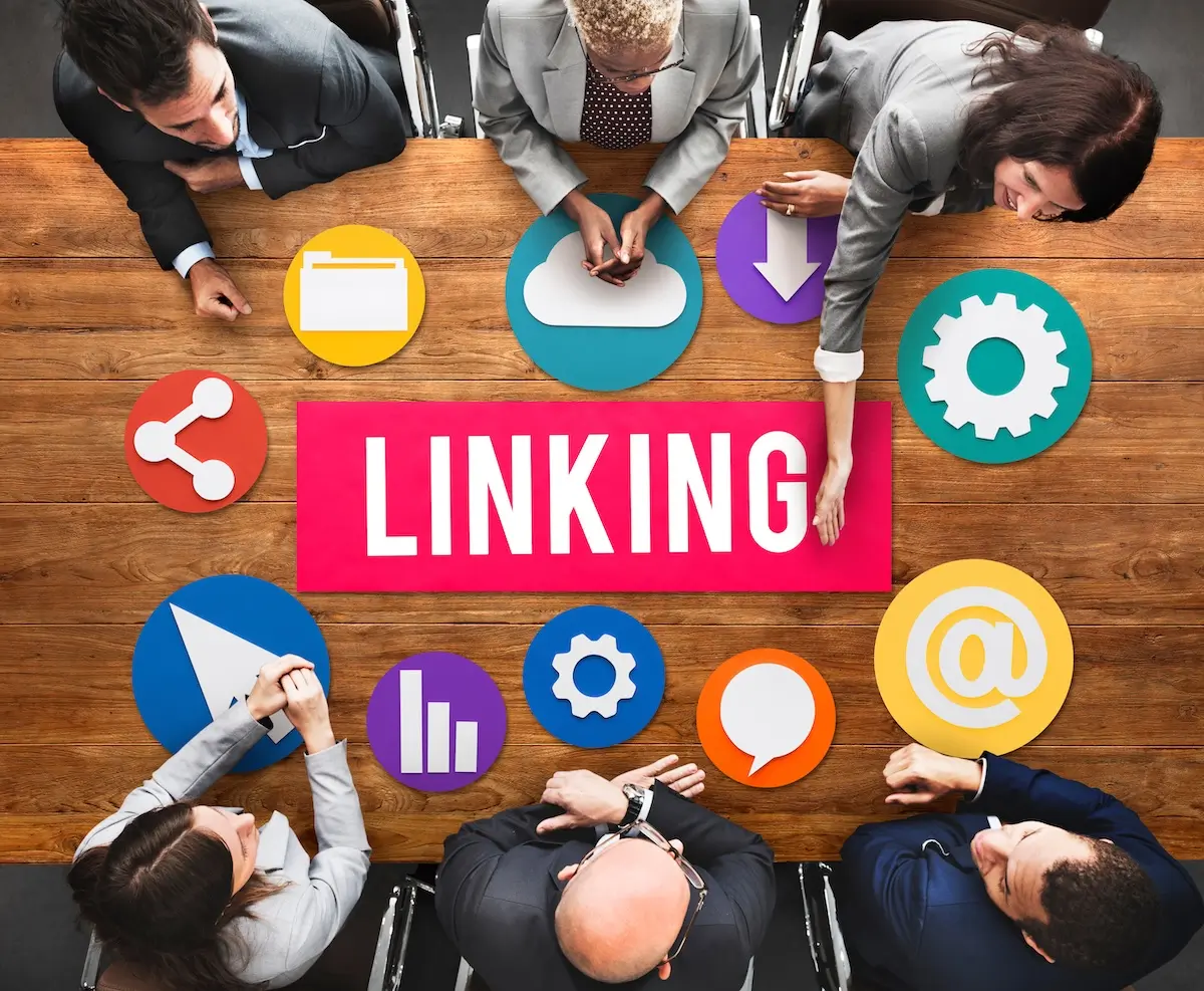 6 people at a Backlinks meeting - 'Linking' on table