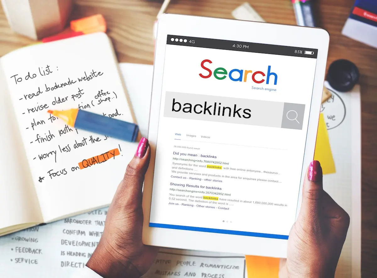 A person holding a tablet with 'backlinks' in a search bar