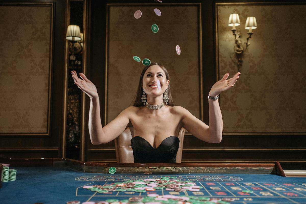 A woman sat at a roulette table throwing chips in the air Pavel Danilyuk on Pexels.com