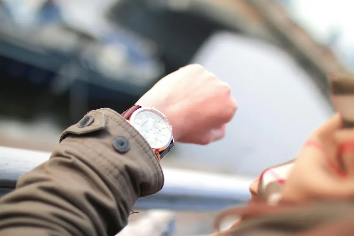 Person checking the time of their watch, wondering when they will see results from the marketing agency by Jeshoots on Pexels. com