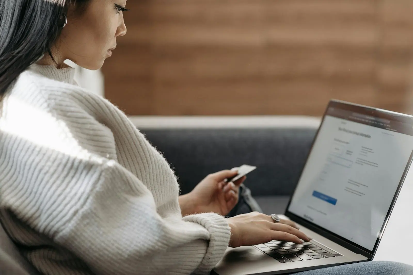 Woman in White Sweater Entering Card Details into Laptop doing SEO by Pavel Danilyuk on pexel.com