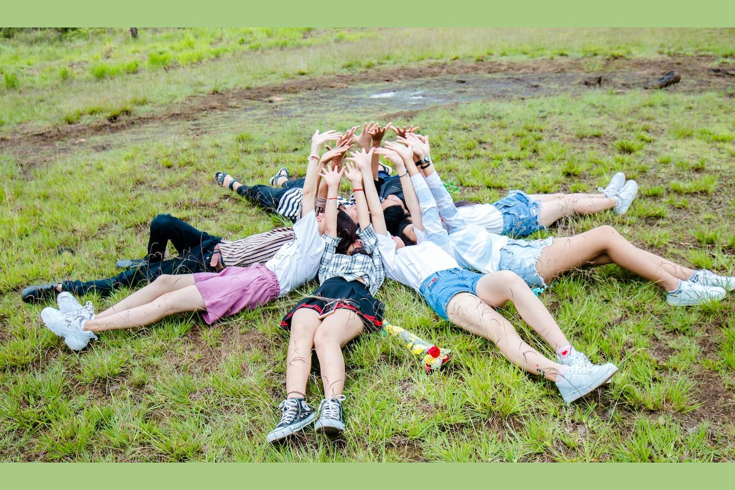 8 friends lying on the grass with their heads next to each other and hands in the air, signifying Hyper-Personalisation At Scale by Chu Chu Phinh on pexels. com