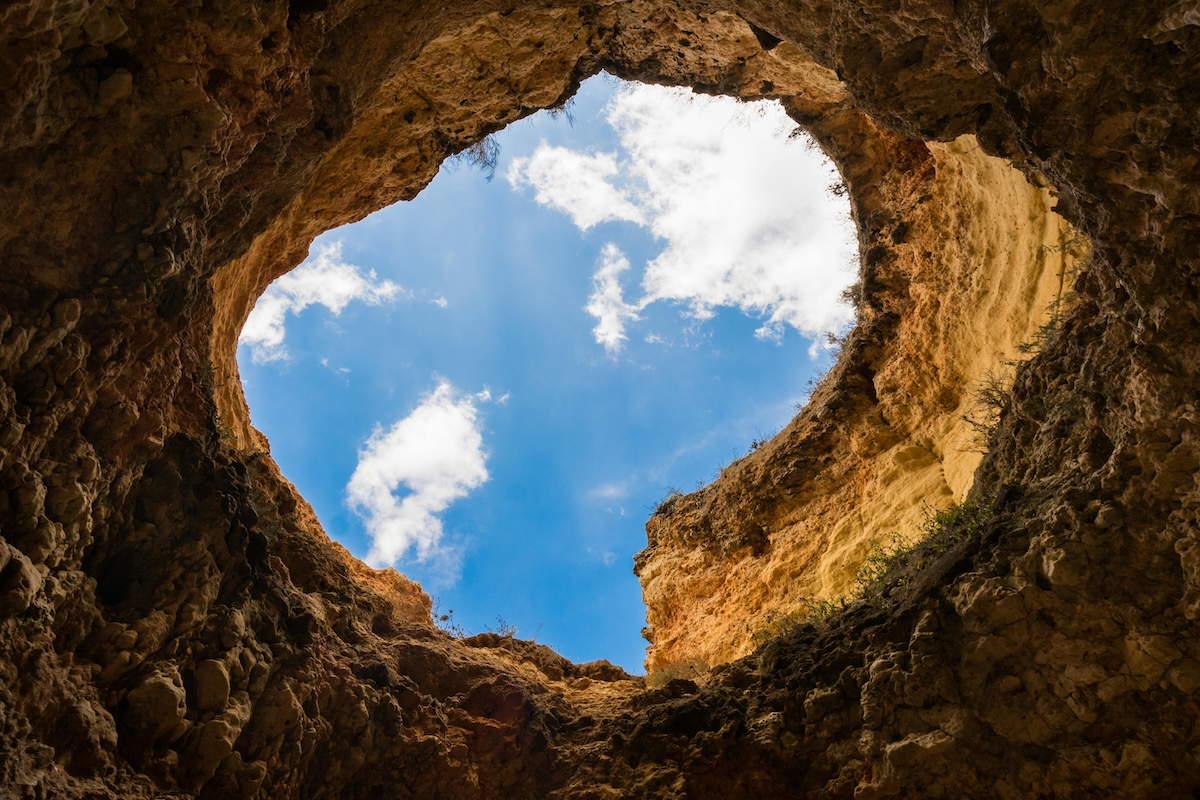 A view from inside a cavern looking up at the sky. Metaphor of Engine Optimization