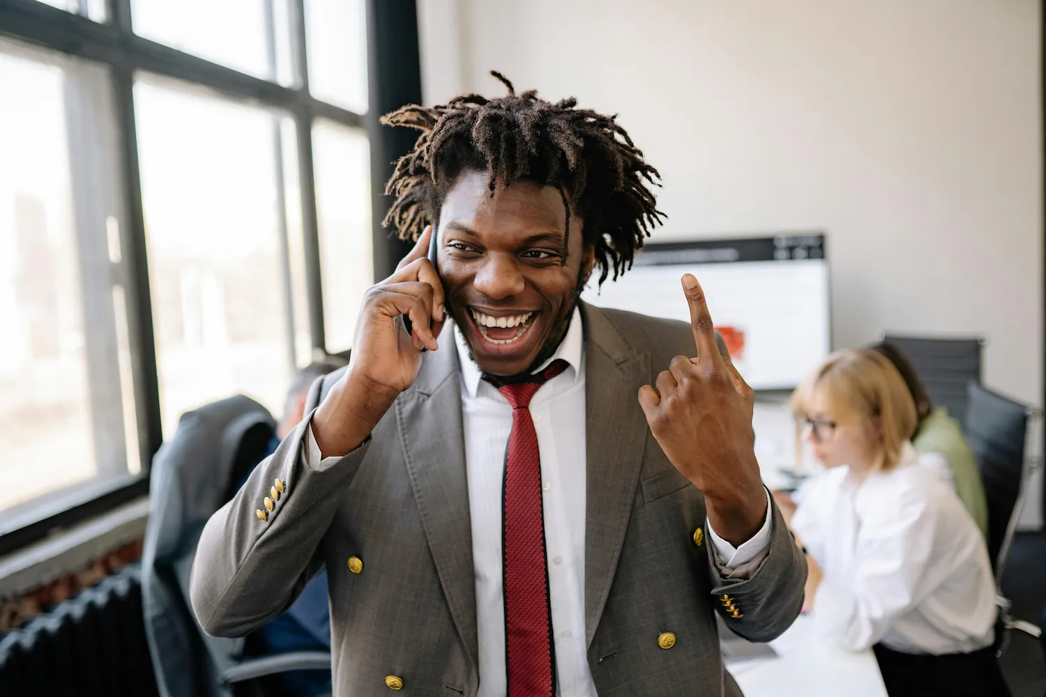 Black man smiling on phone, pointing upwards for organic traffic by Yan Krukau Pexels
