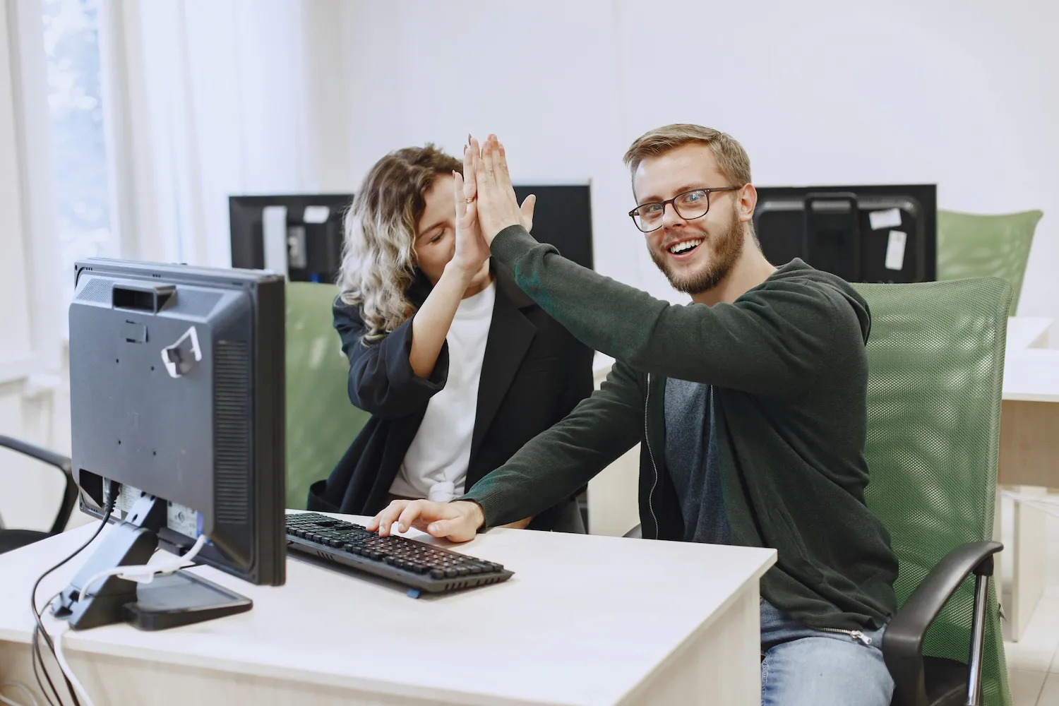 Woman and man high-fiving while on a computer using a search engine by Gustavo Fring on Pexels