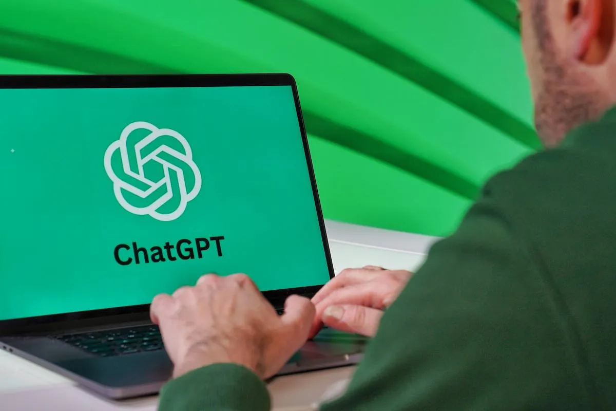 Man Using ChatGPT on Laptop with Green Background by UMA media