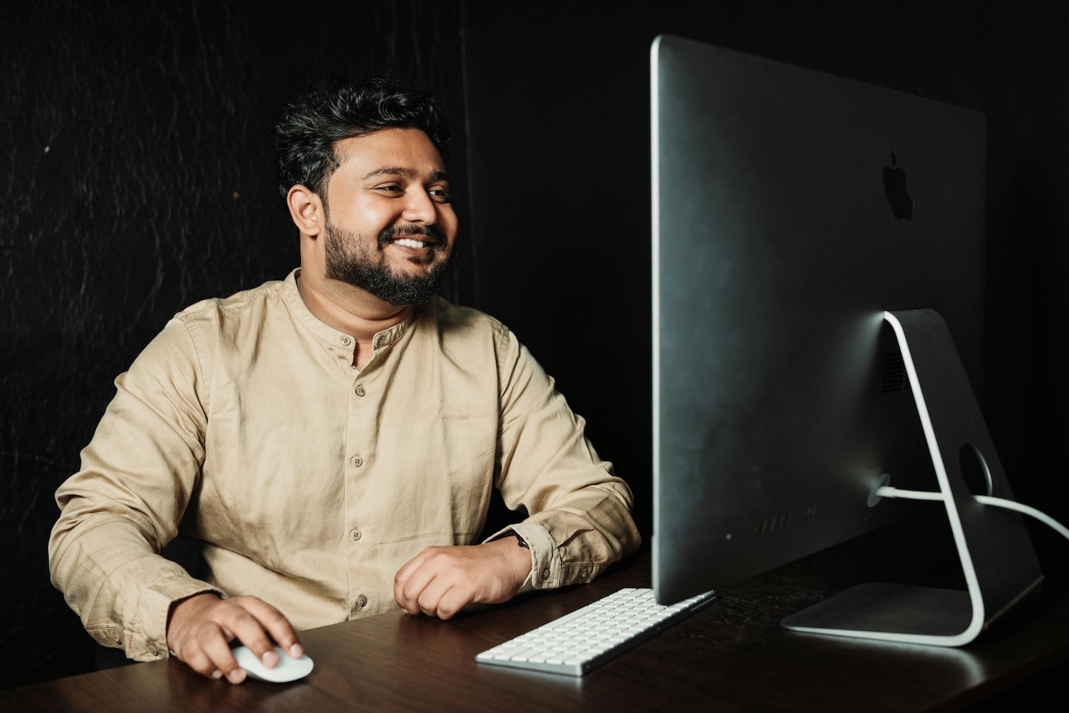 A man smiling as he uses paid search on a computer by Aathif Aarifeen on Pexels