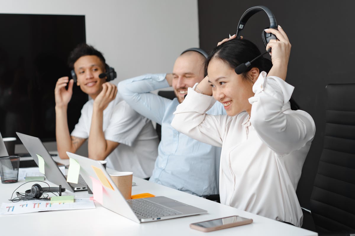 Woman in a White Shirt Taking Off Her Headset in her remote work by Mikhail Nilov
