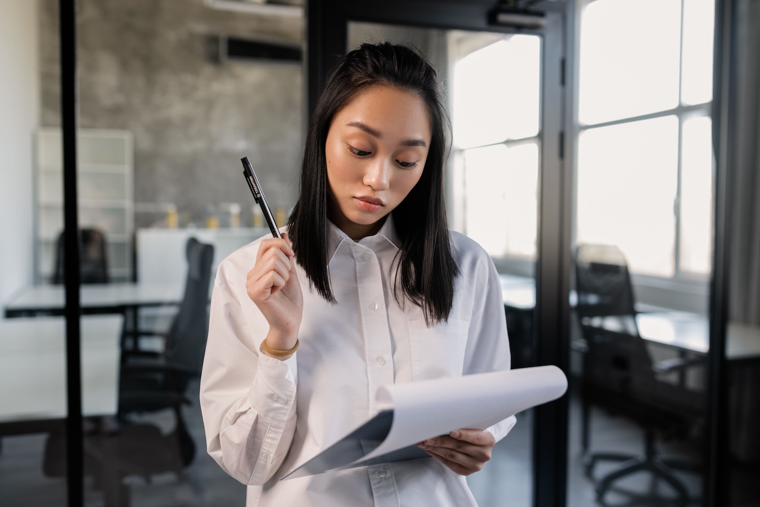 An east asian female looking at an Investors sheet by Alena Darmel on Pexels
