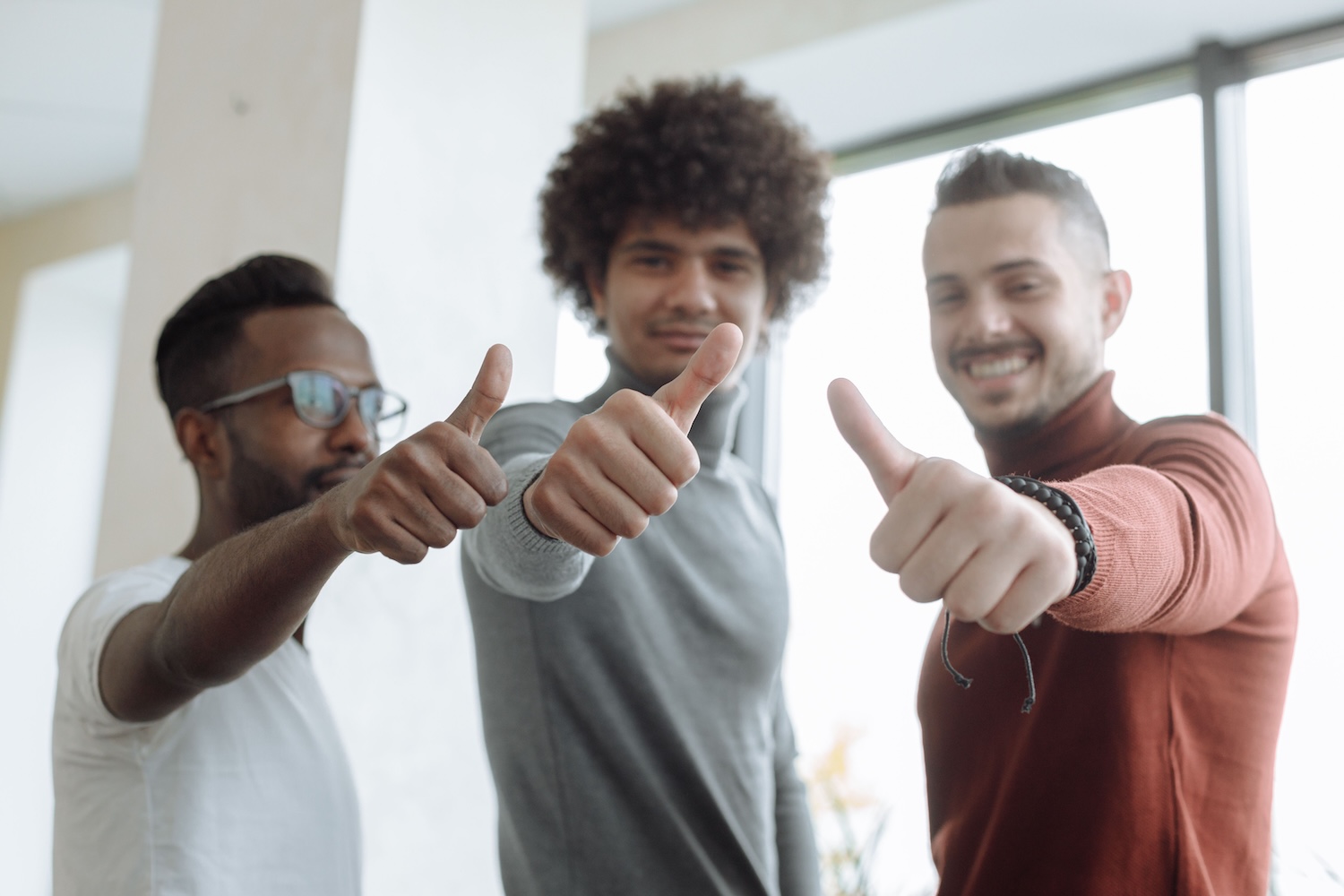 Three young men doing a thumbs up to the camera by Thirdman on pexels