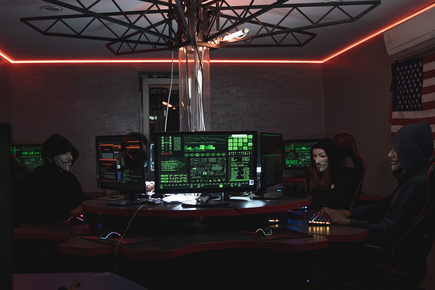A dark room with three hackers doing a Google Account Hack on computers by Tima Miroshnichenko on Pexels