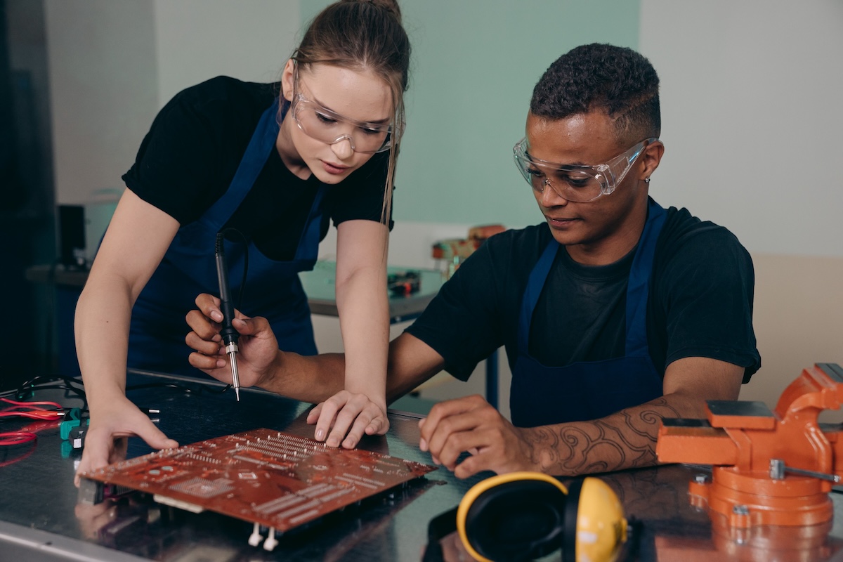 Hardware operators working on a motherboard by Mikhail Nilov on Pexels