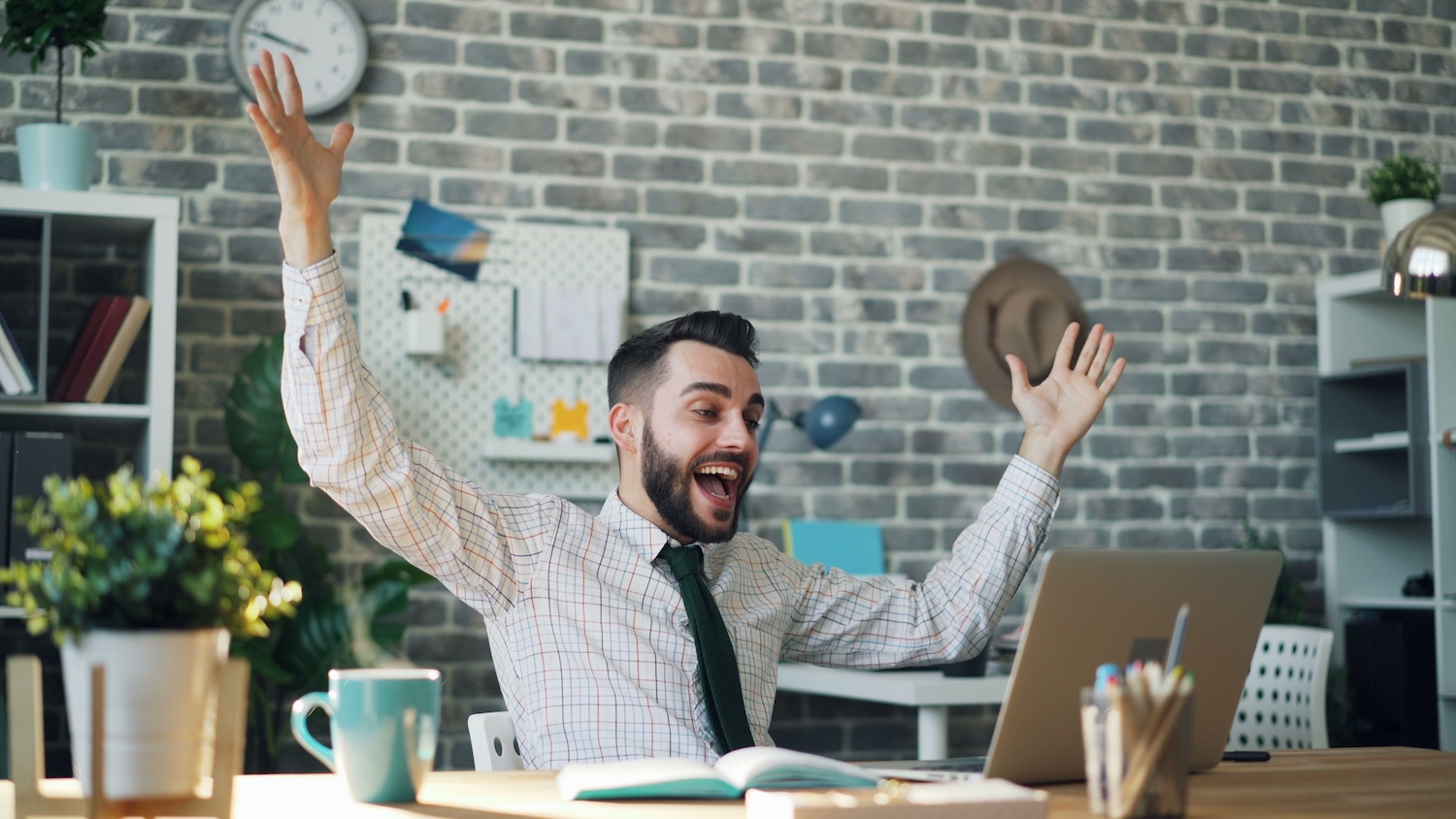 Office man at his desk with both arms up and wide with joy about his AI SDR by Vitaly Gariev on Pexels